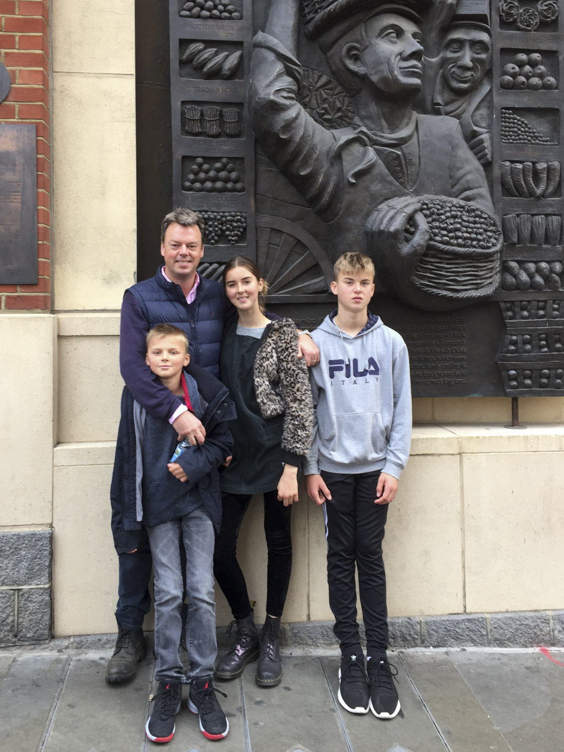 Will Beeson, great grandson of William Beeson, and his three children standing by the memorial to the businesses which operated in Covent Garden market, where trading in fruit, veg and flowers continued for 150 years from the early 1800s to 1974.